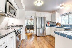 A modern kitchen with stainless steel appliances, white cabinetry, and a wooden floor. - 12 Mi to Folsom Historic District: Norcal Getaway (Sacramento)