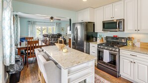 A kitchen with white cabinets, stainless steel appliances, and a marble countertop. - Walk to Sandusky Bay: Home w/ Hot Tub & Fire Pit! (Sandusky)