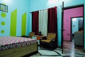 A bedroom with a bed, a desk, a chair, and a wardrobe.