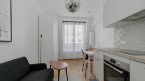 Eine moderne Küche mit Essbereich, einer Couch und einer Pendelleuchte.