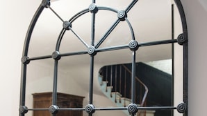Ein Spiegel mit schwarzem Metallrahmen und geometrischem Design.