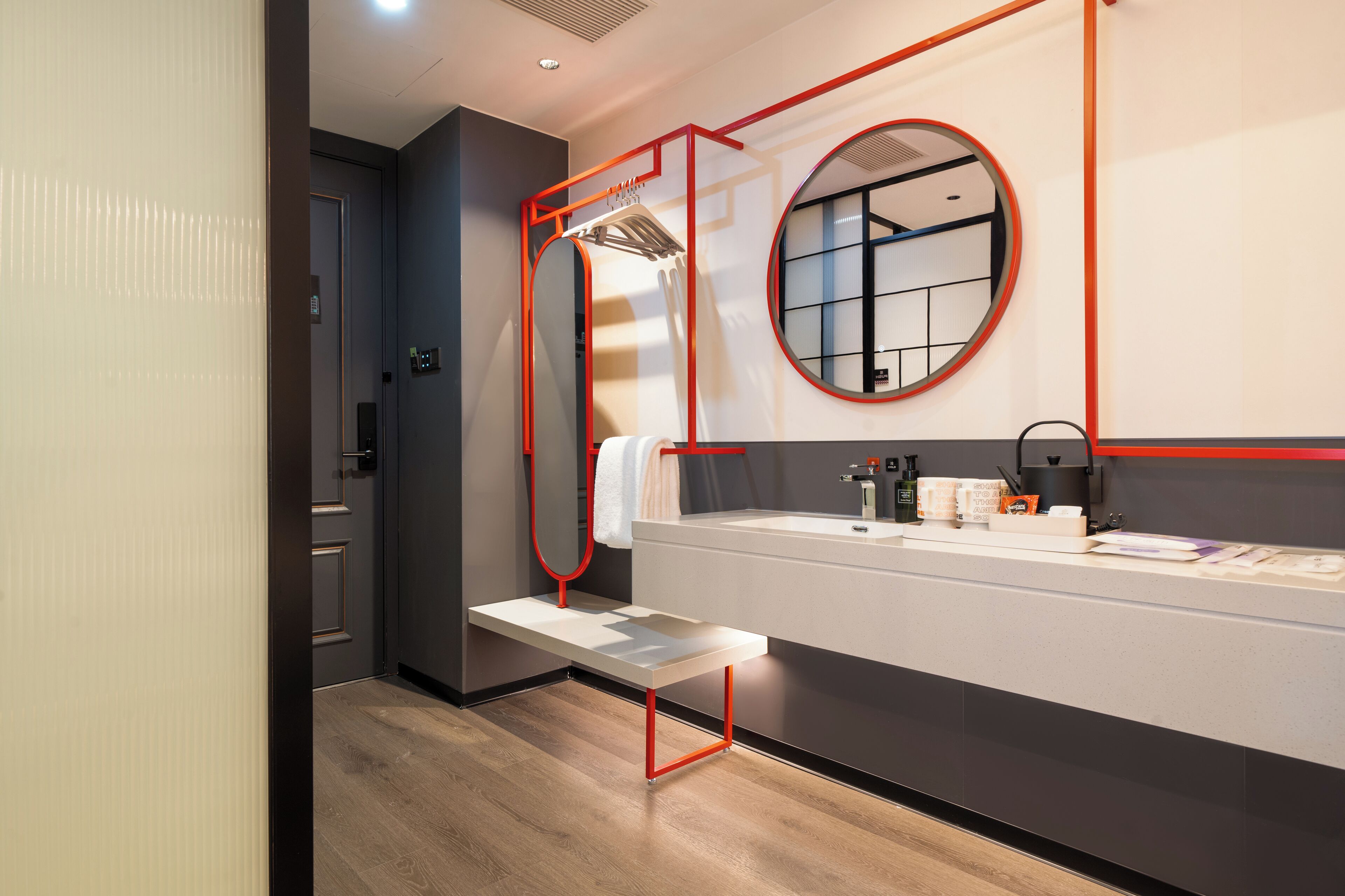 A modern bathroom with a bench, a mirror, and a sink.