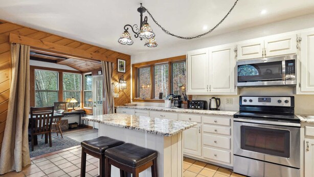 A kitchen with white cabinets, a granite countertop, a stainless steel oven, and a microwave. - 4 BR Home near Lake: 6 min to Okemo Mtn. (Ludlow)
