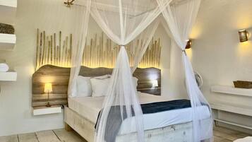 Un dormitorio con cama a dosel, lámparas de noche y una lámpara fijada a la pared.