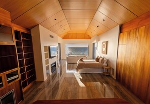 Une chambre dotée d’une grande fenêtre, d’un plafond en bois et d’étagères intégrées.