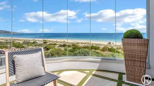 A corner balcony with a clear view of the beach and ocean.