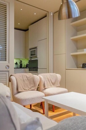 Een modern interieur met een bank, een tafel en een keuken in de achtergrond.
