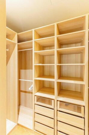 A wooden closet with multiple shelves and drawers.