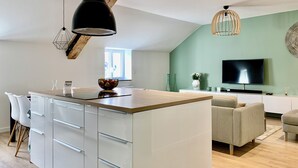 Una cucina moderna con isola centrale, mobili bianchi e luci a sospensione.