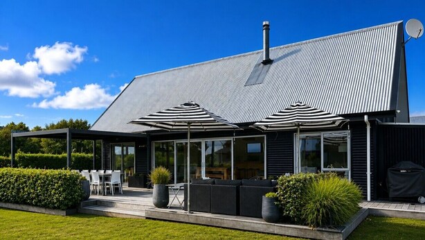 A modern house with a large patio, outdoor seating, and a satellite dish.