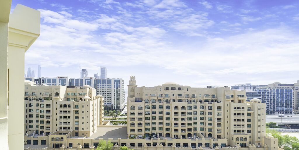 A high-rise hotel with multiple floors, large windows, and a prominent tower.
