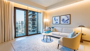A modern living room with a sofa, armchair, coffee table, and artwork.