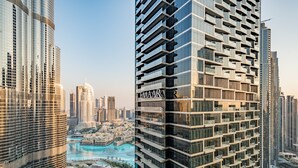 A high-rise building with a modern design, featuring multiple balconies and a prominent "EMAAR" sign.