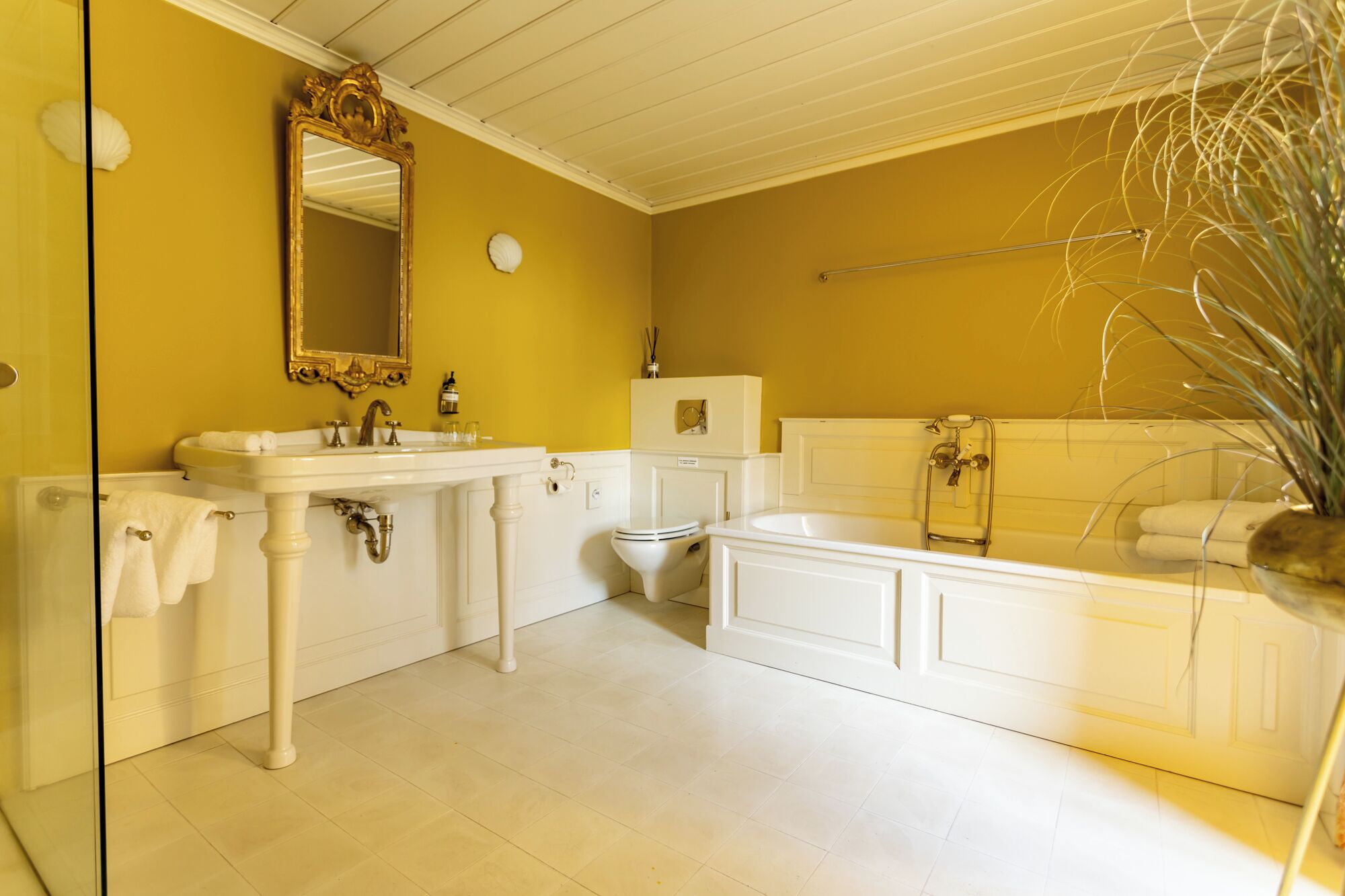 Ein Badezimmer mit einem weißen Waschbecken, einer Toilette und einer Badewanne.