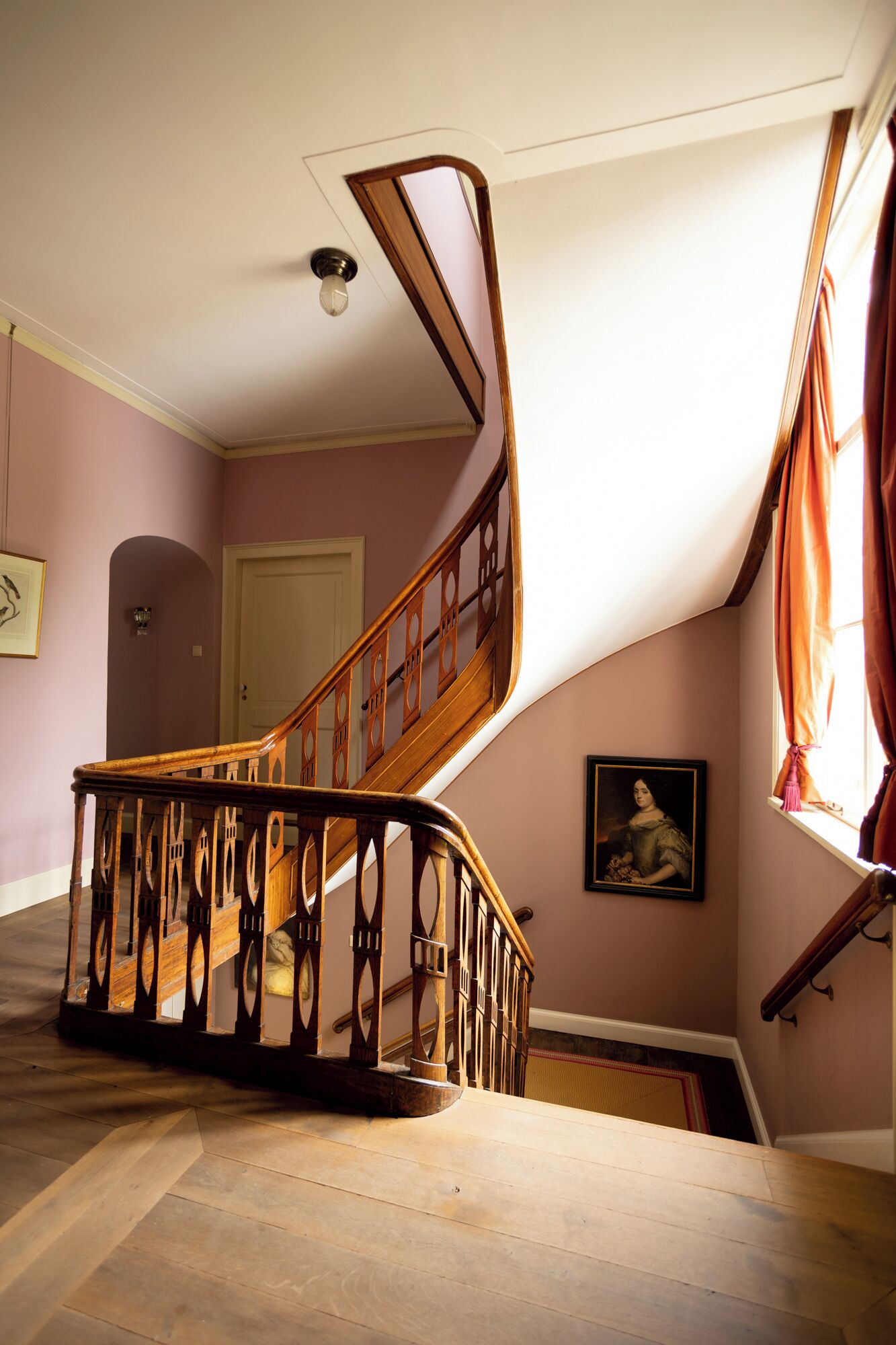 A wooden staircase with intricate railings leading to a landing.