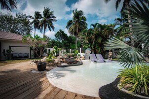 Una piscina al aire libre, sillones reclinables de piscina