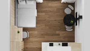 Ein kompaktes Studioappartement mit Bett, Küchenzeile und kleinem Badezimmer.