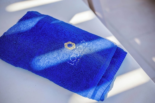 Een blauwe handdoek met een logo en tekst op een witte ondergrond.