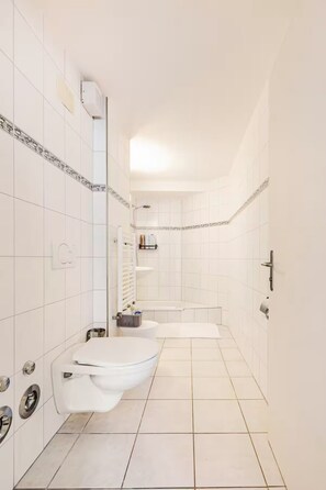 Un baño moderno con dos lavamanos, un inodoro y una bañera.
