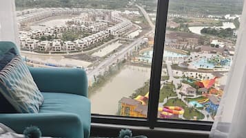 Una habitación con un ventanal que da a un parque acuático y una zona residencial.
