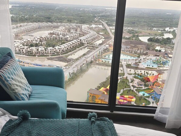 A room with a large window overlooking a water park and a residential area.