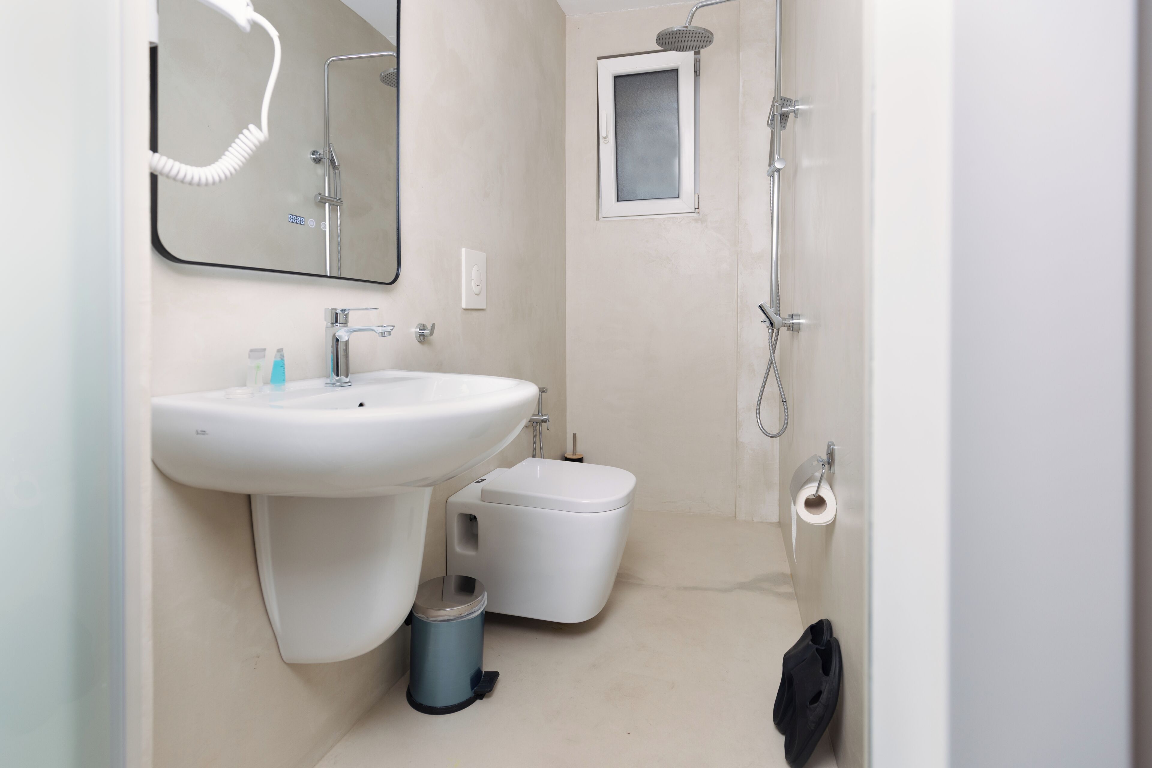 A bathroom with a sink, toilet, bidet, and a mirror.