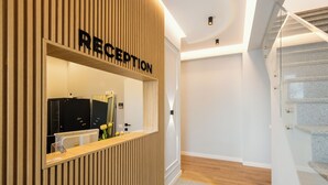 Un área de recepción con paneles de madera, un mostrador y una escalera.