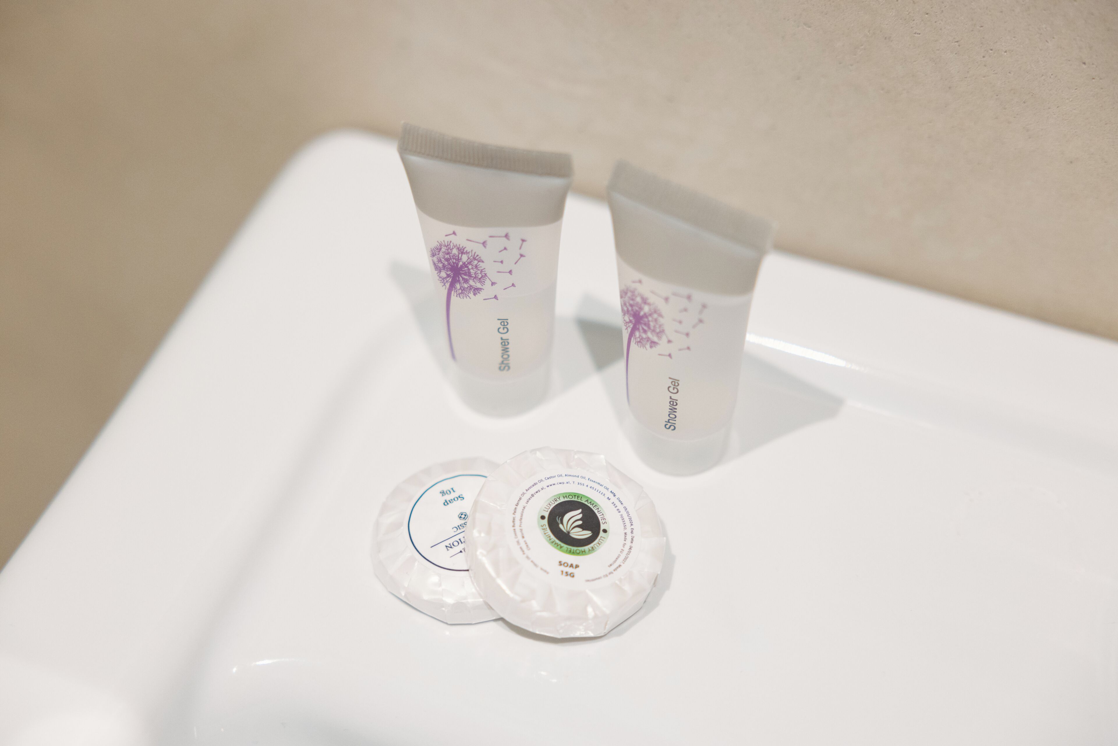 Dois tubos de gel de banho e dois sabonetes em uma superfície branca.