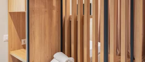 Una habitación de madera con una pila de toallas y un perchero de madera.