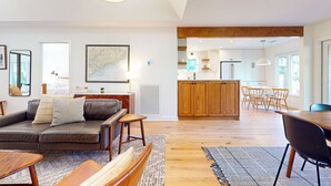 Una sala de estar moderna con un sofá, una mesa de centro y un comedor con sillas y una mesa.