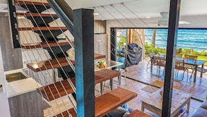 A modern interior with a staircase, wooden flooring, and a dining area with outdoor views.