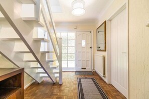 A staircase leading to a landing with a white door and a mirror on the wall. - Host & Stay | Alderfen View (Norwich)