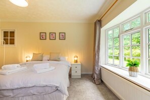 A bedroom with a bed, bedside tables, a window with curtains, and a radiator. - Host & Stay | Alderfen View (Norwich)