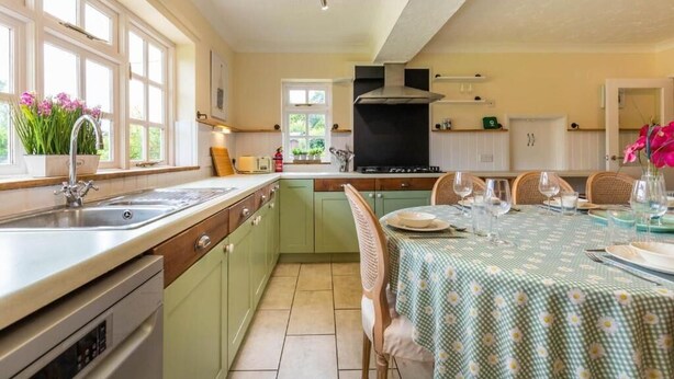 Una cocina con comedor, que cuenta con un ventanal grande, un horno empotrado y una mesa de comedor para cuatro.