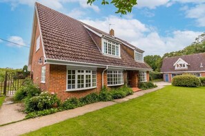 A two-story house with a sloped roof, brick exterior, and a front garden. - Host & Stay | Alderfen View (Norwich)