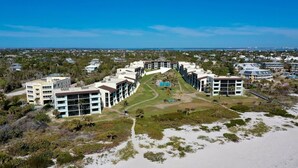 A coastal hotel with multiple buildings, a central courtyard, and beachfront access.