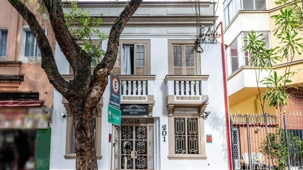 A hotel entrance with a sign for Monte Castello Hotel, number 201, and a directional sign for Glória. - HOTEL MONTE CASTELO LTDA. (Rio de Janeiro)
