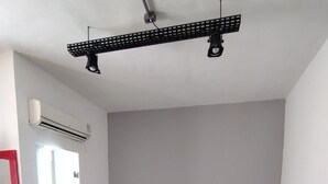 A modern hotel room with a large bed, a bedside table with a lamp, a wall-mounted TV, and a door leading to another room. - HOTEL MONTE CASTELO LTDA. (Rio de Janeiro)