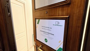 A wooden door with a framed certificate of certification for a bed-and-breakfast. - Casa Anatrella Comfort House (Naples)