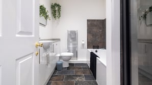 Ein modernes Badezimmer mit Toilette, Waschbecken und Badewanne.