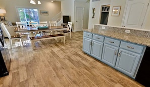 A kitchen with a dining table, light blue cabinets, and a wooden floor.