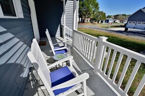 A porch with white railings, two blue cushioned chairs, and a small round table. - New Bethany Beach DE Luxury House in Bethany West: (Bethany Beach)