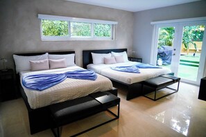 A hotel room with two beds, a bench, a small table, a window, and a sliding door to a balcony. - Luxury Resort • Gym, Cold Plunge, Jacuzzi & Sauna (Miami)