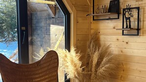 A cozy room with a large window, a wooden ceiling, a woven basket, and a cat bed. - Mountain homes Durmitor 2 (Uskoci)