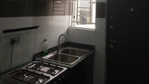 Een keuken met een gasfornuis, een spoelbak en een raam met uitzicht.