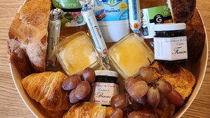 Una bandeja con diversos alimentos, como pan, queso y uvas.