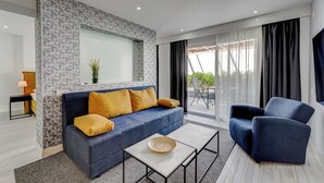 A modern living room with a blue sofa, a blue armchair, and a white coffee table. - BAL One bedroom apartment Adults Only (101) (Arona)