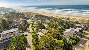 Zona residencial costera con casas, una playa y cielo despejado.