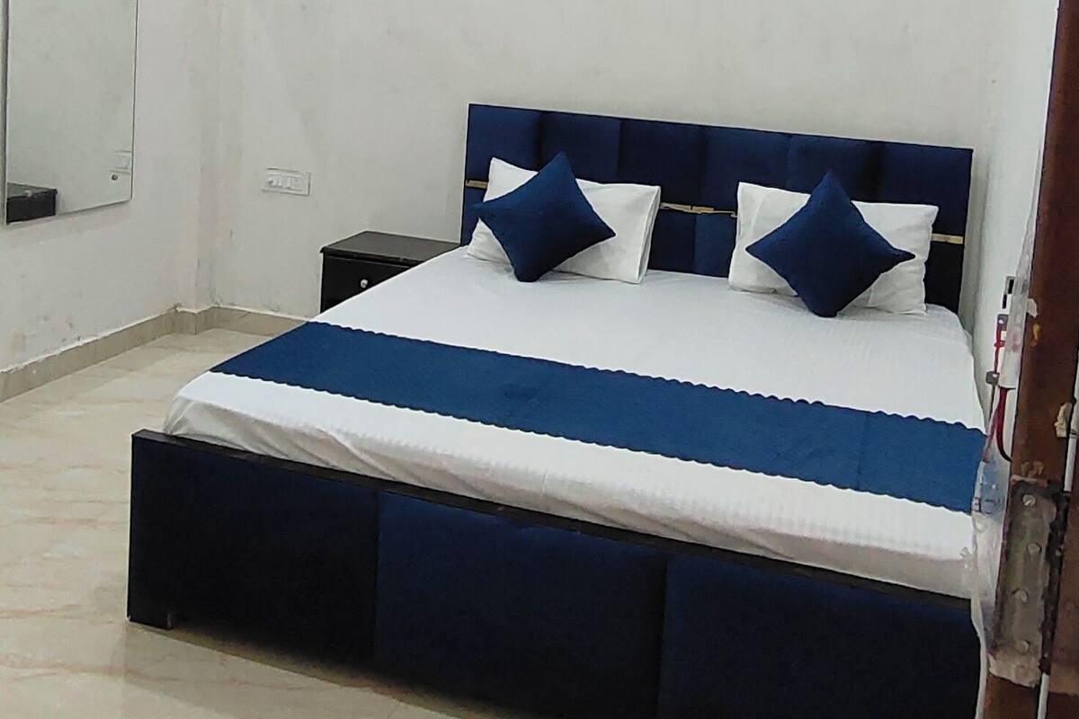 A bedroom with a bed, a ceiling fan, and a nightstand.