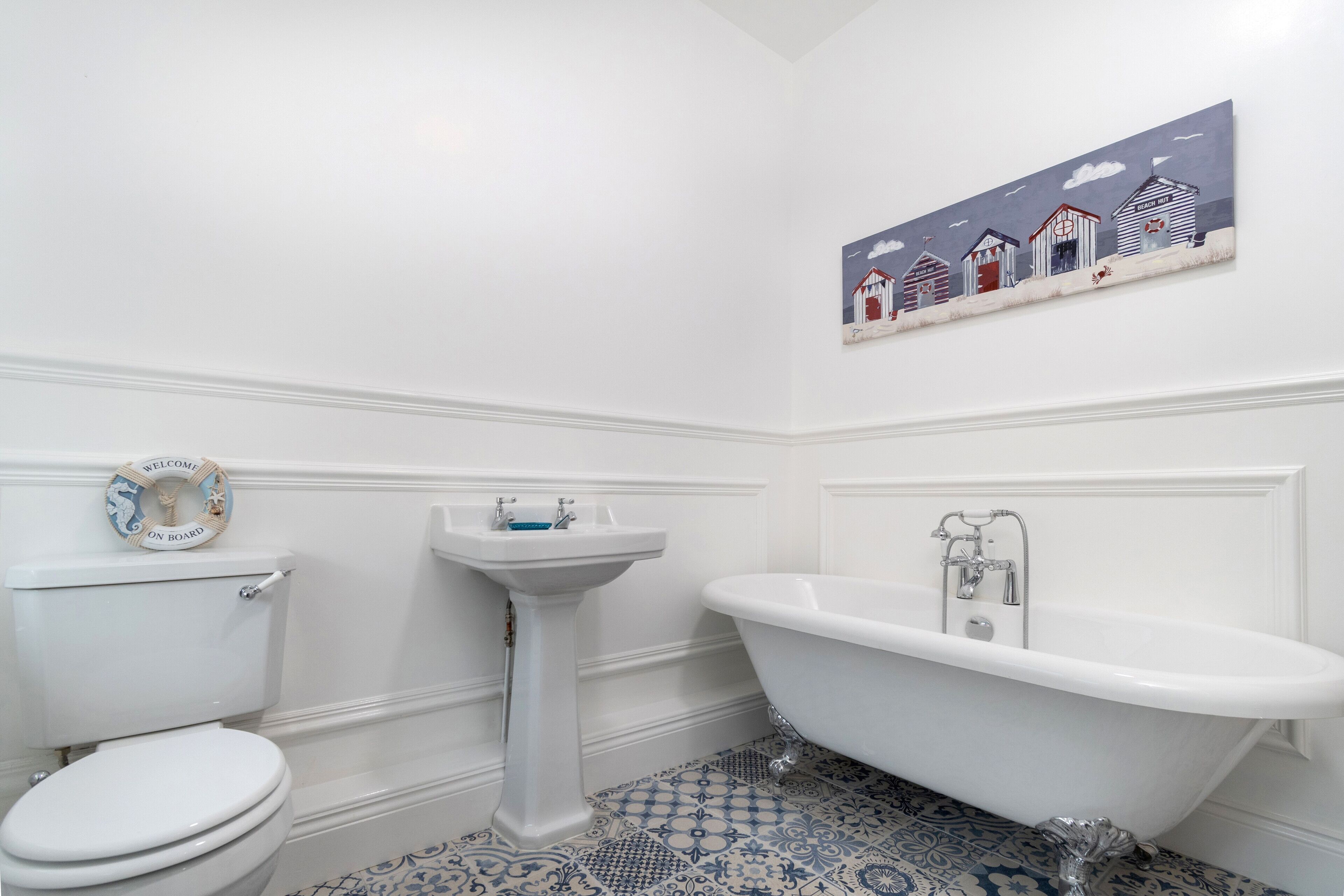 Ein Badezimmer mit Toilette, Waschbecken auf Fuß und Badewanne mit Pfotenfüßen.